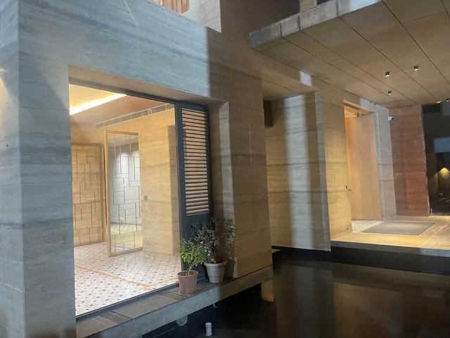 Travertine-clad entrance with warm evening lighting