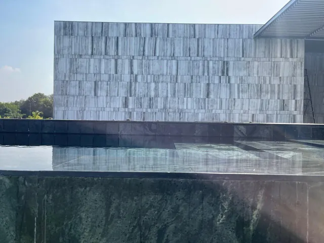 Striped grey-and-white stone cladding wall above a pool
