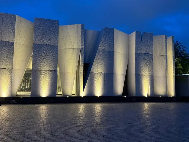 Angular white stone façade lit at dusk