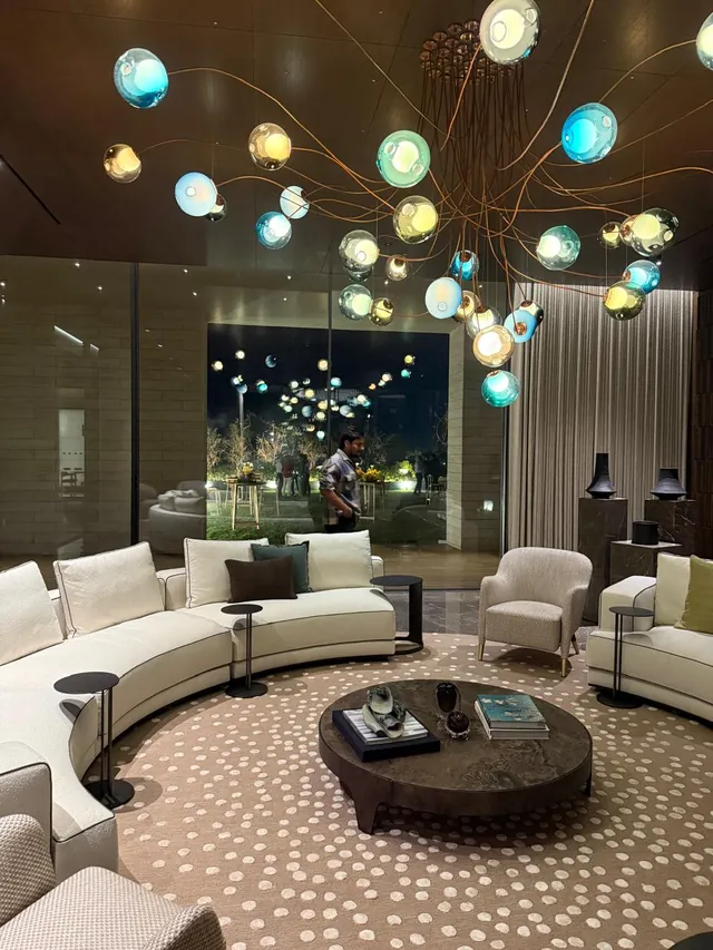 Living room with stone flooring under a glass-orb chandelier