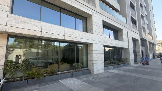 Travertine-clad façade with glazed shopfronts